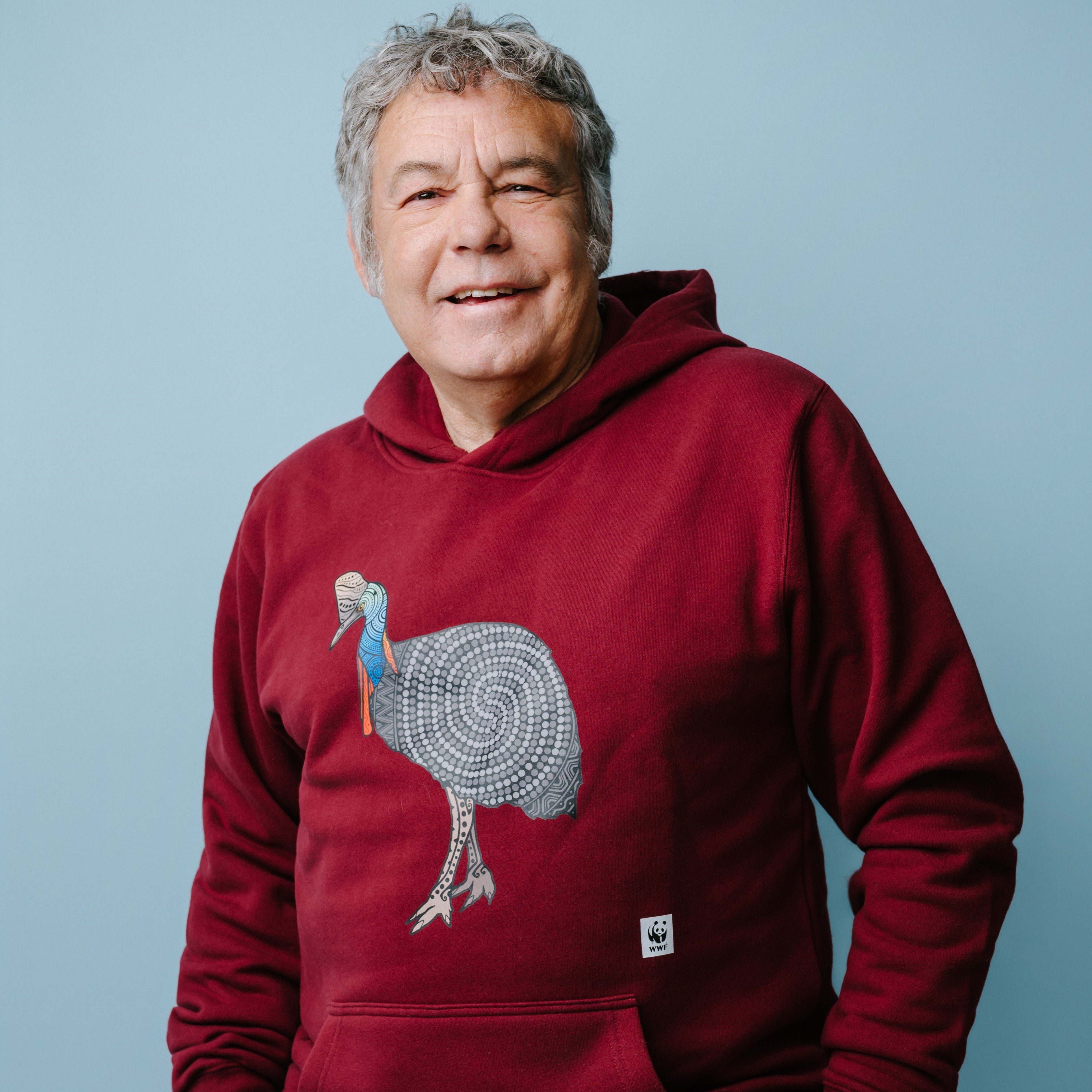 Man wearing a dark red hoodie with a cassowary graphic design on a blue background. WWF-Australia product.
