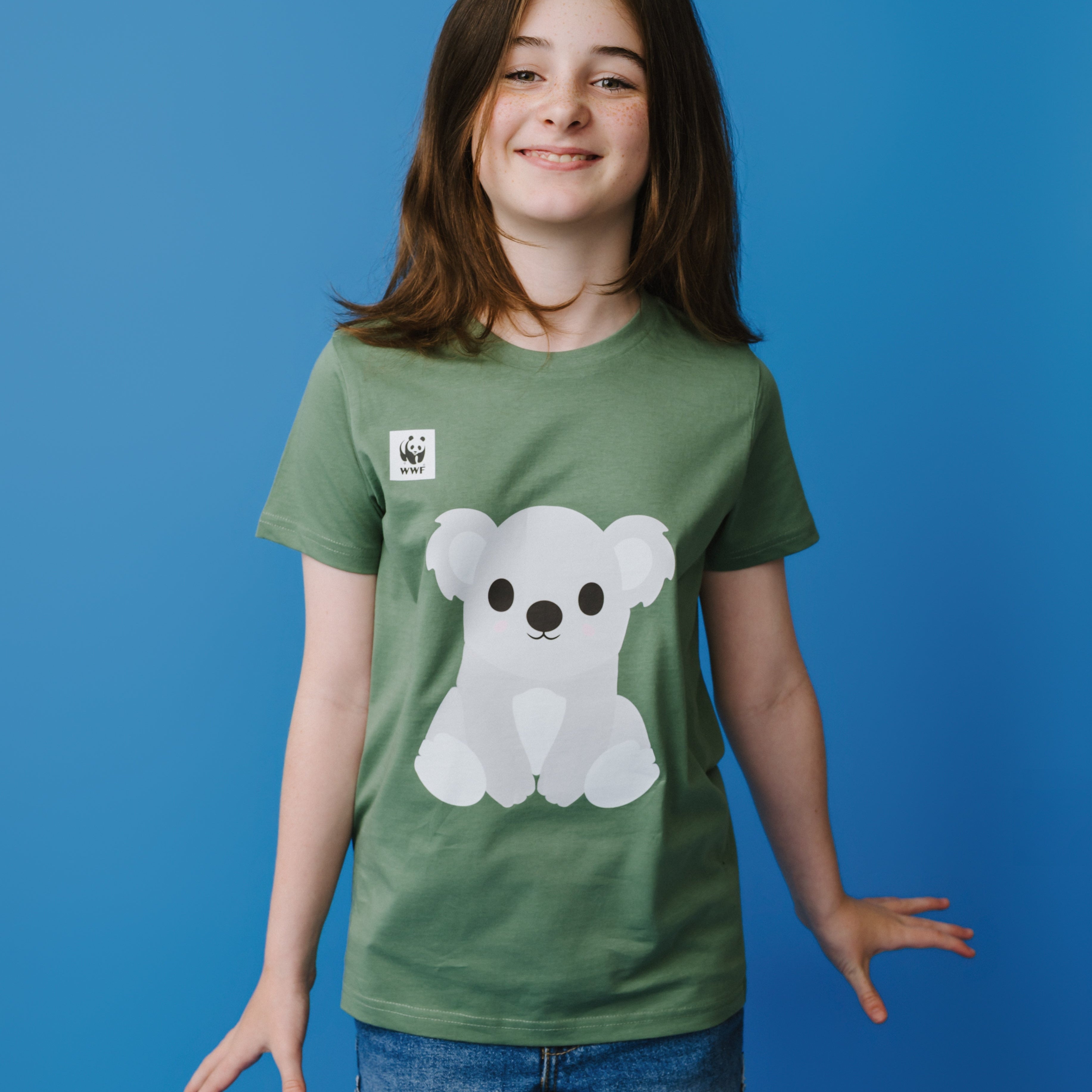 Child wearing a green t-shirt with a koala graphic on a blue background.